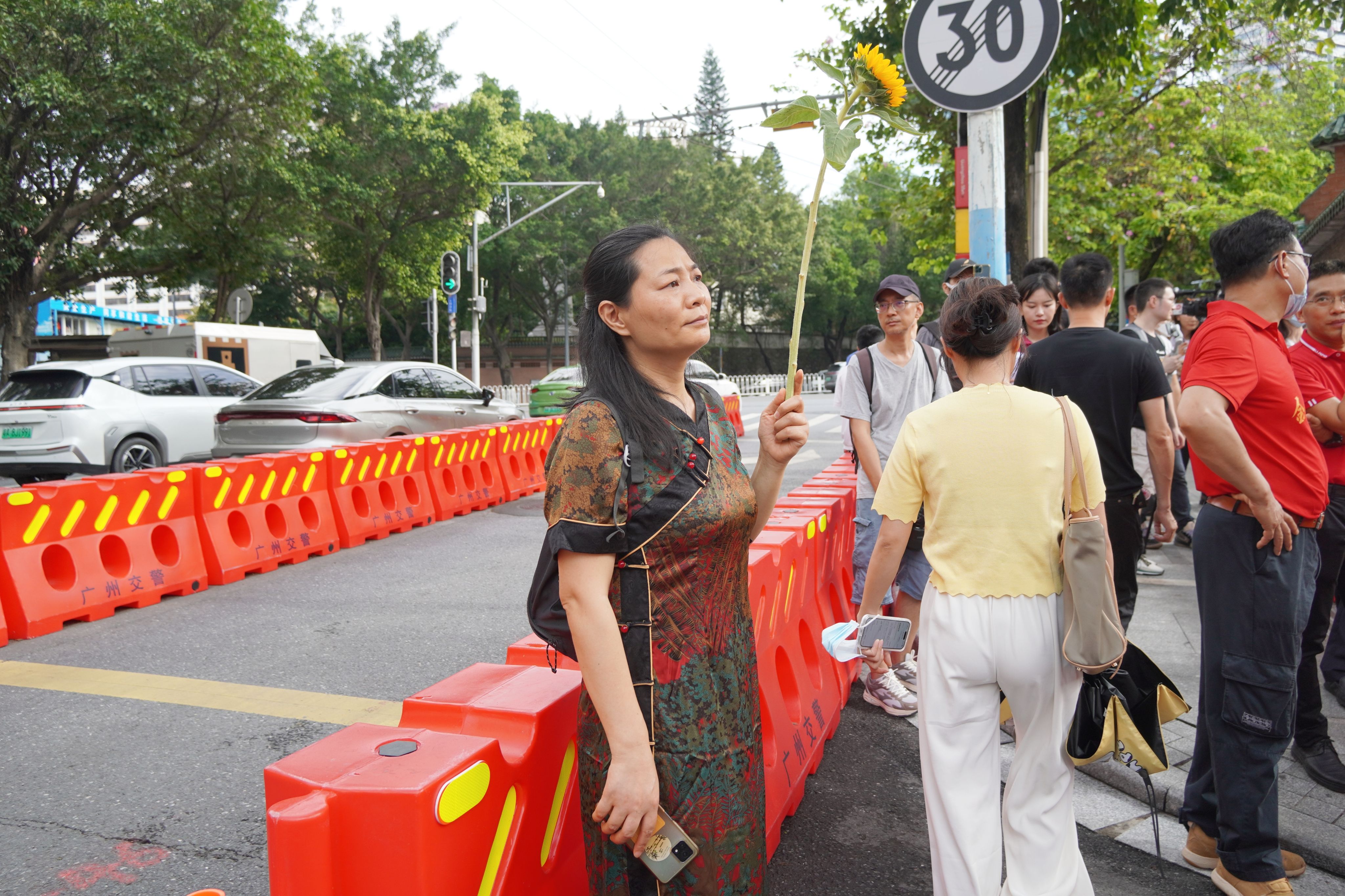 在廣東省廣州市高考考點，一位母親手捧寓意祝福的向日葵等待考生。王雅蝶 攝