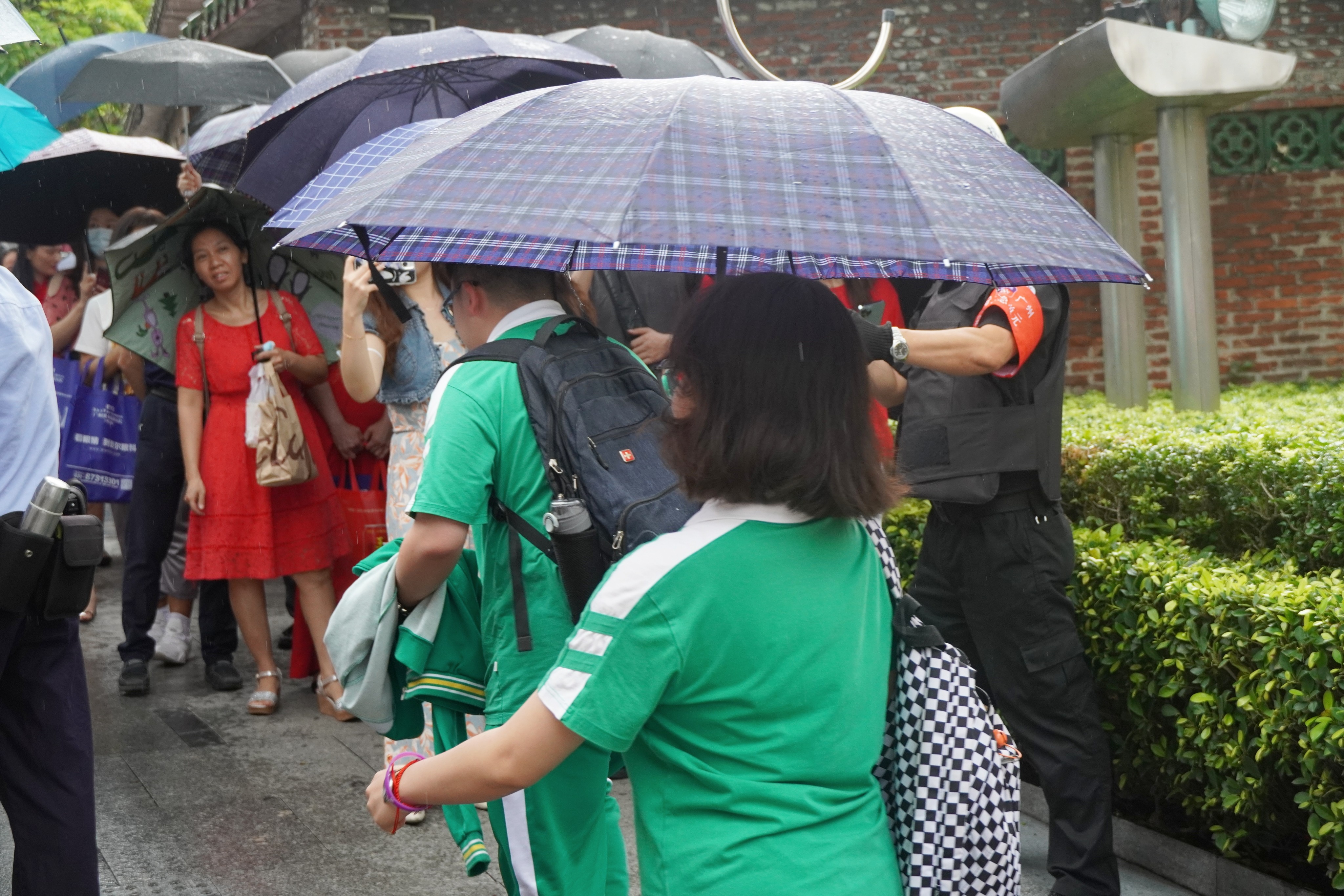 高考首日，在廣東省廣州市一高考考點(diǎn)，考生陪考家屬冒雨等待孩子。王雅蝶 攝